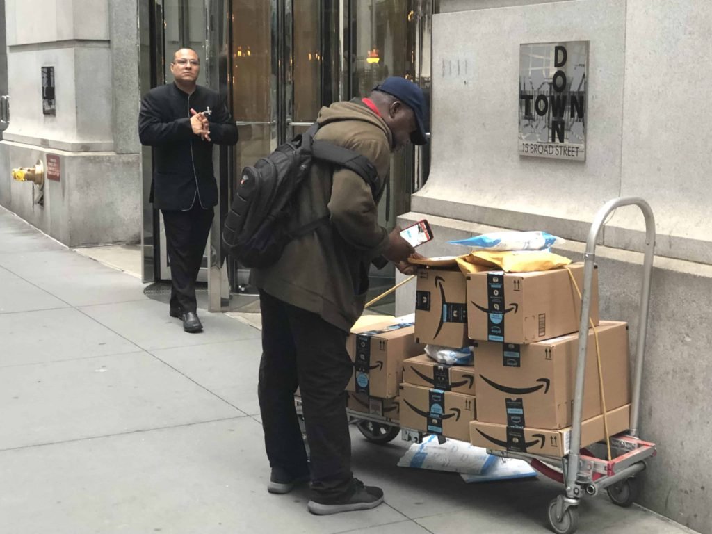 Een man levert Amazonpakketjes in downtown New York