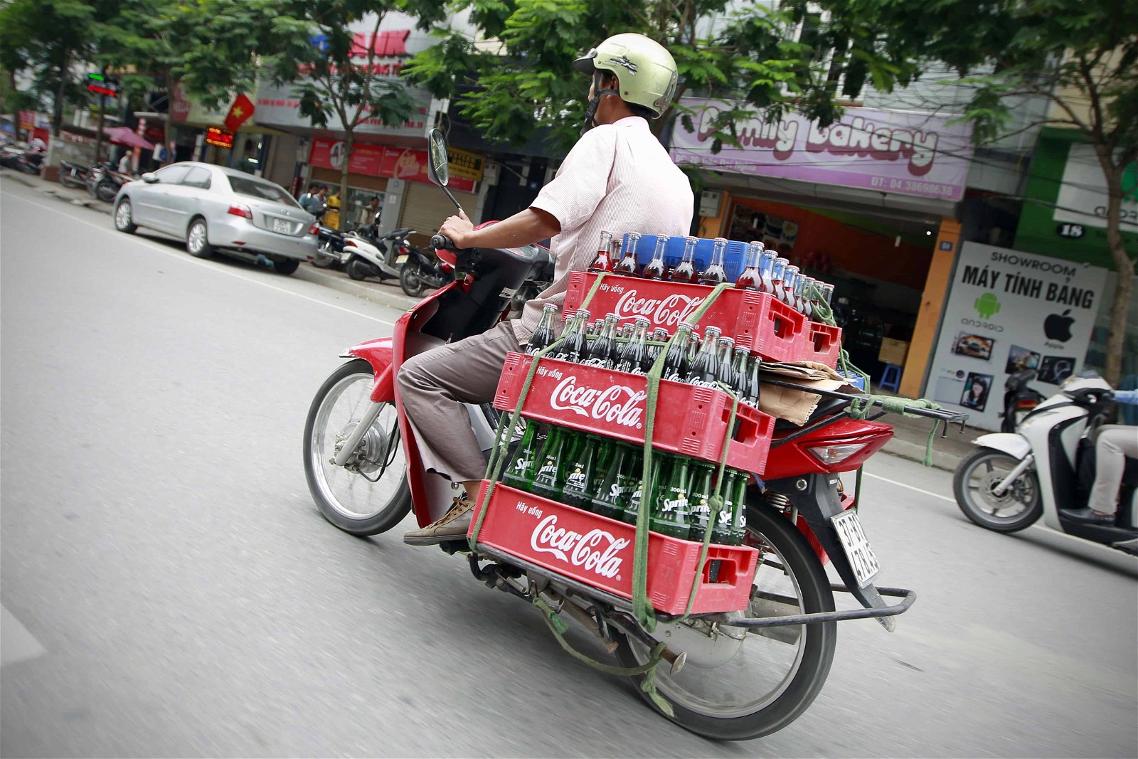 Un scooter chargé de Coca-Cola roule dans une rue du Vietnam.