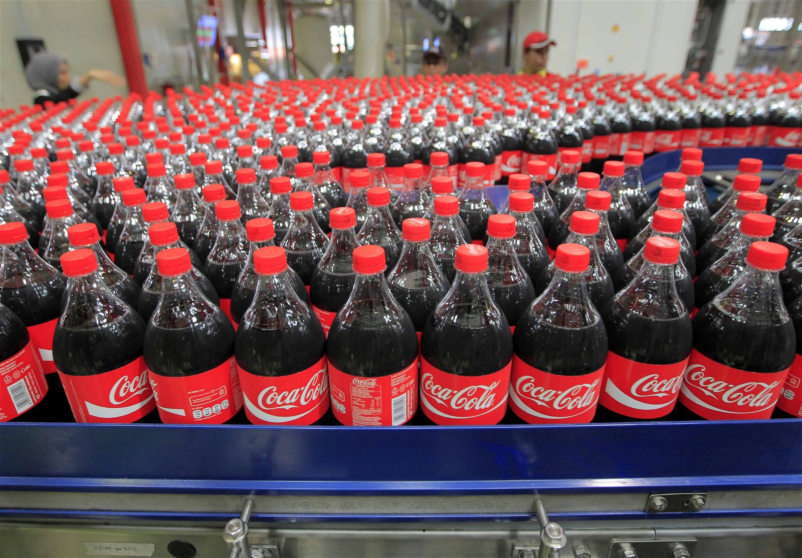 Een groot aantal Coca-Cola-flessen rolt van de band.