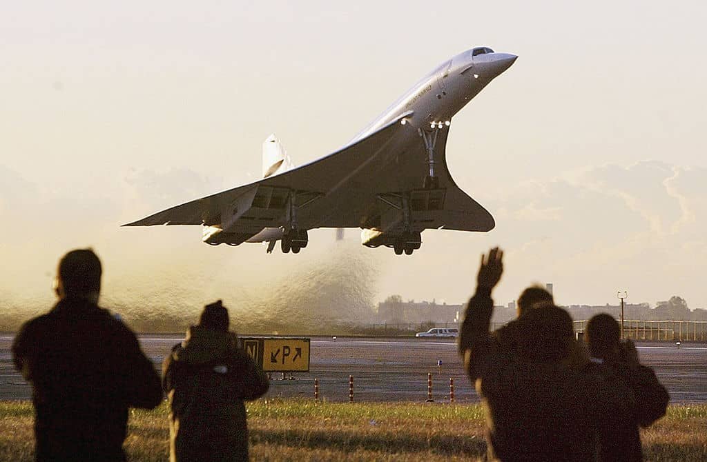 Mensen zwaaien naar de Concorde die voor hen opstijgt.