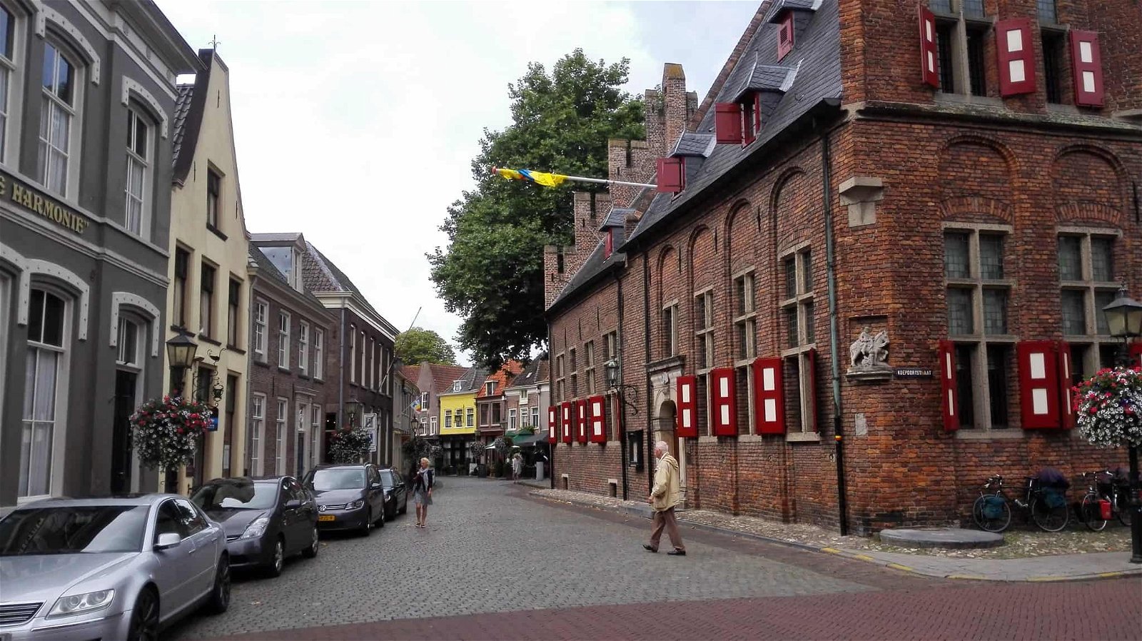 Een man loopt over de straat naast een historisch gebouw in Doesburg.