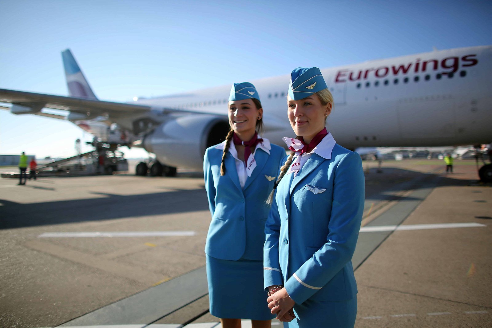 Twee stewardessen staan voor een vliegtuig van Eurowings.
