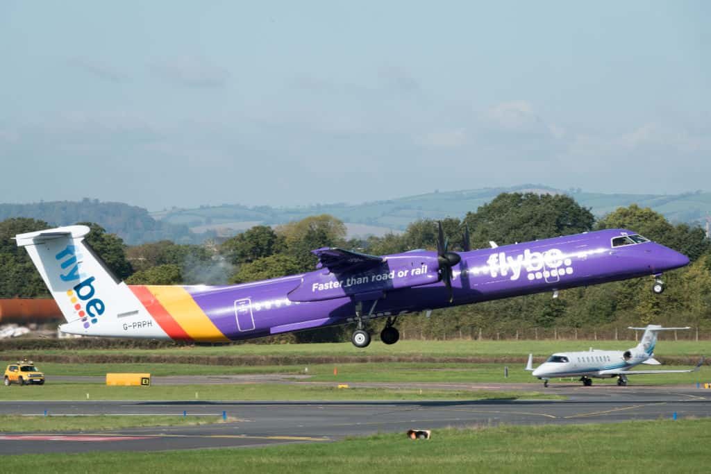 Een blauw vliegtuig van low cost-maatschappij Flybe stijgt op.