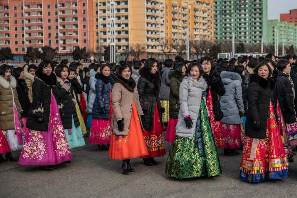 Een groep vrouwen loopt in traditionele klederdracht door Pyongyang.