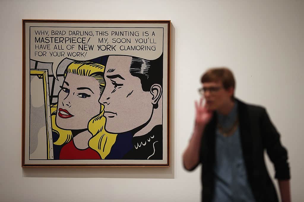 Een vrouw gebaart met haar hand aan haar mond naast een schilderij waarop twee stripfiguren staan afgebeeld.