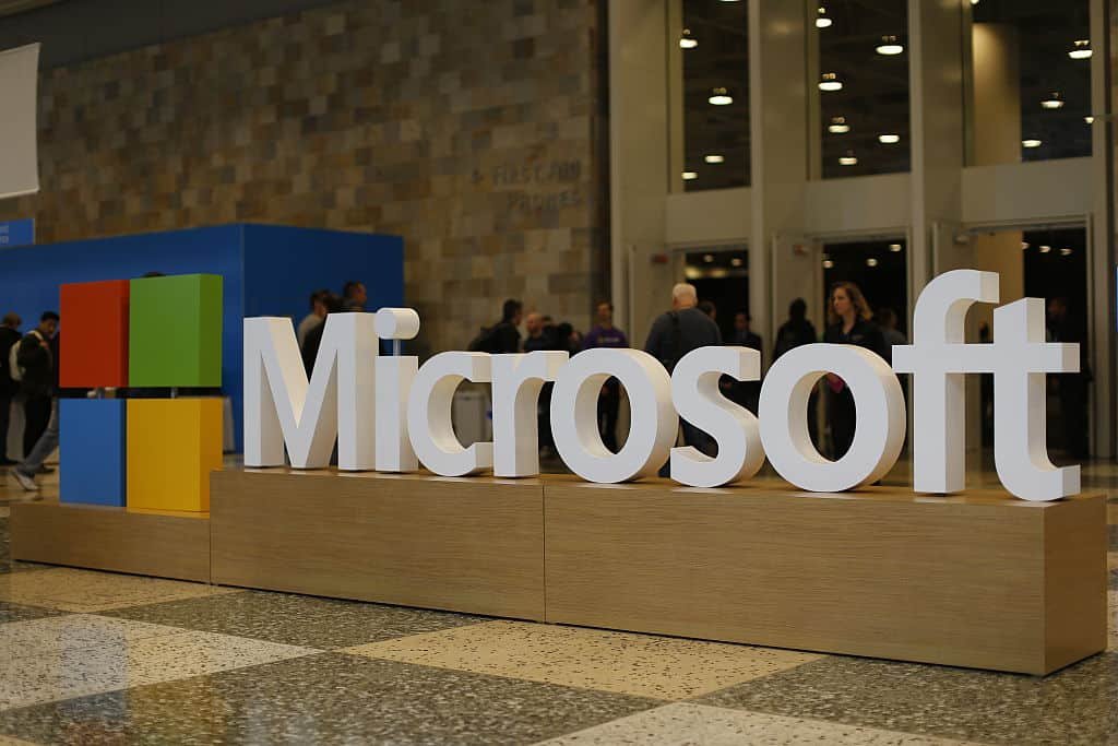 Het logo van Microsoft staat in witte letters op een houten balustrade.