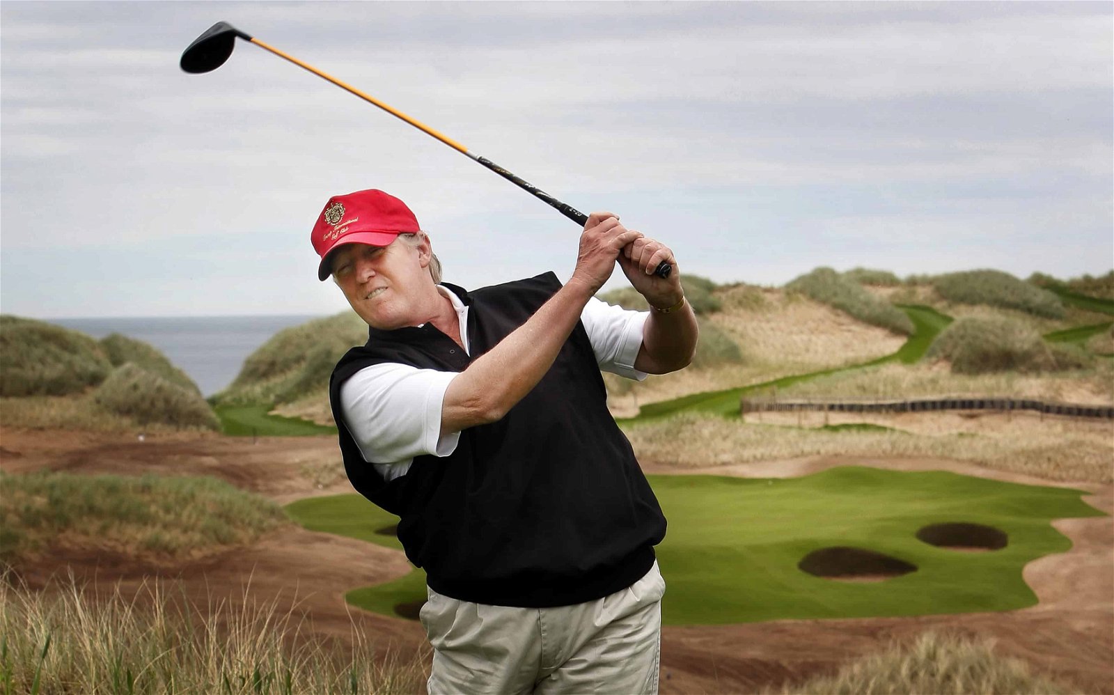 Donald Trump slaat tegen een bal op een golfterrein