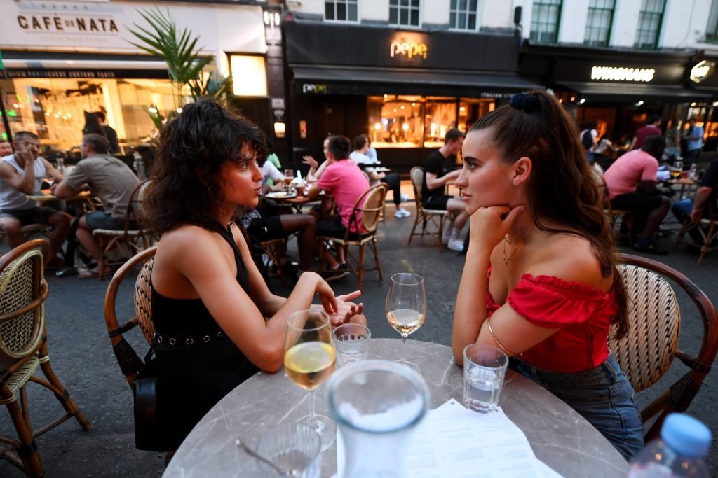 Twee Britse dames drinken wijn in een bar