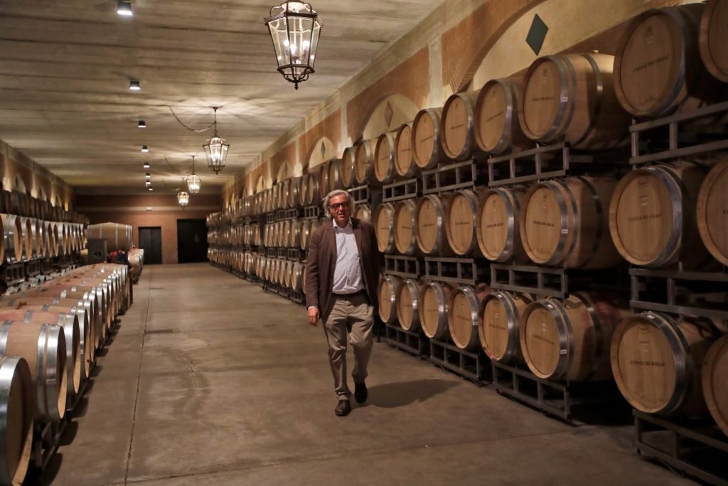 Een Italiaanse wijnmaker loopt in z'n opslagplaats