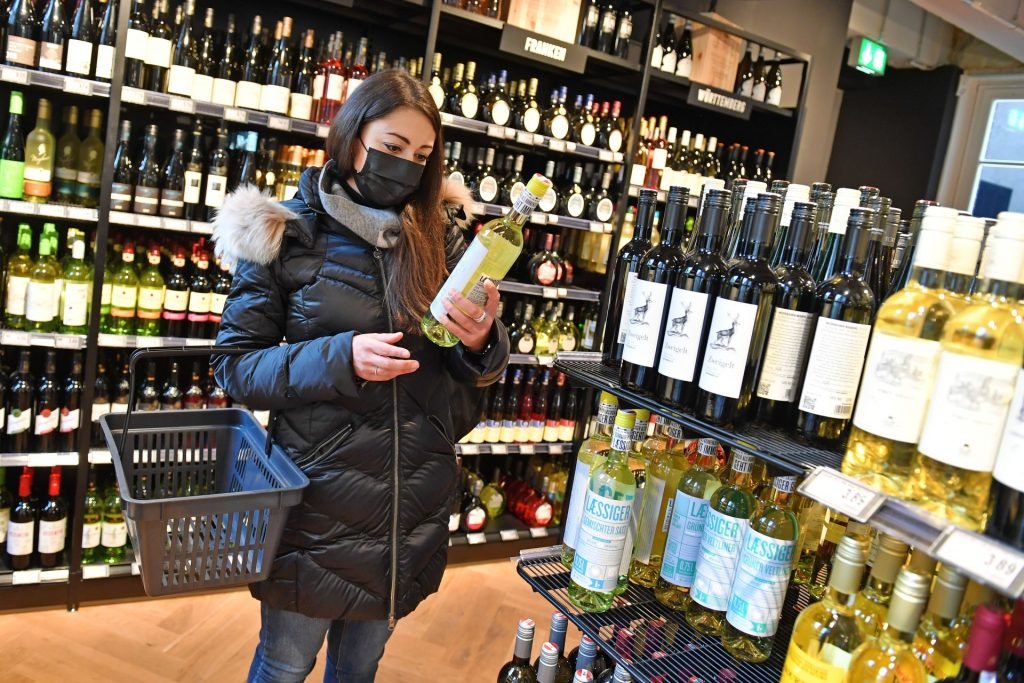 Vrouw koopt wijn in de supermarkt