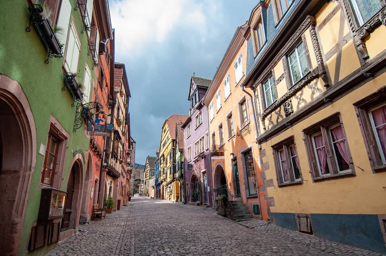 Kleurrijke huisjes in een smalle straat in Kaysersberg, een van de mooiste Franse dorpjes.