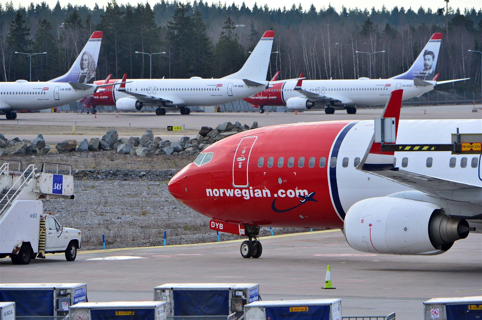 Vliegtuigen van Norwegian staan naast elkaar.