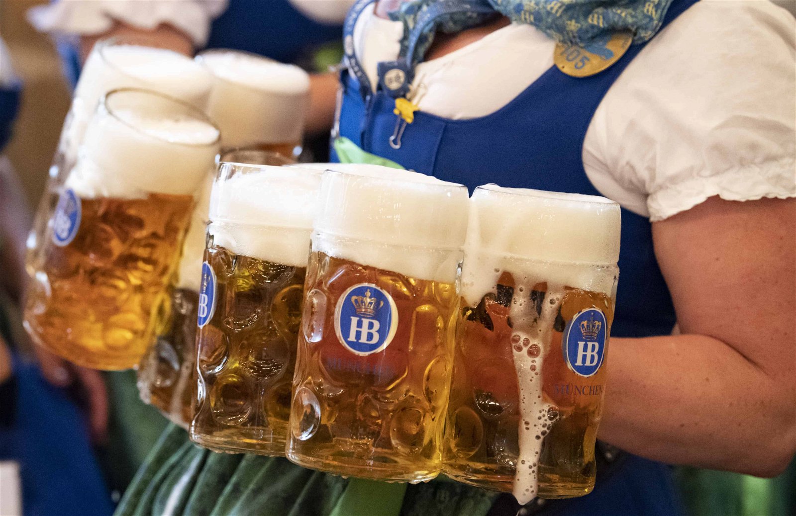 De grandes pintes de bière sont fournies par une femme en costume bavarois.
