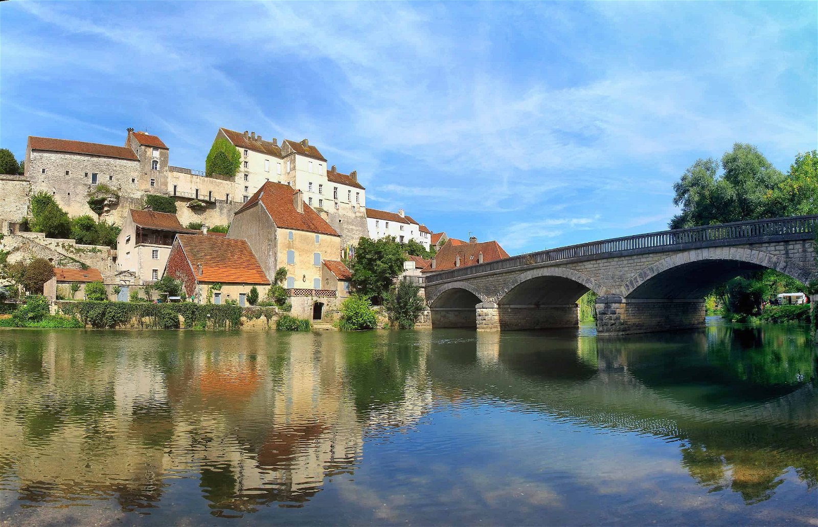 Een brug over het water leidt naar Pesmes, een van de mooiste Franse dorpjes.