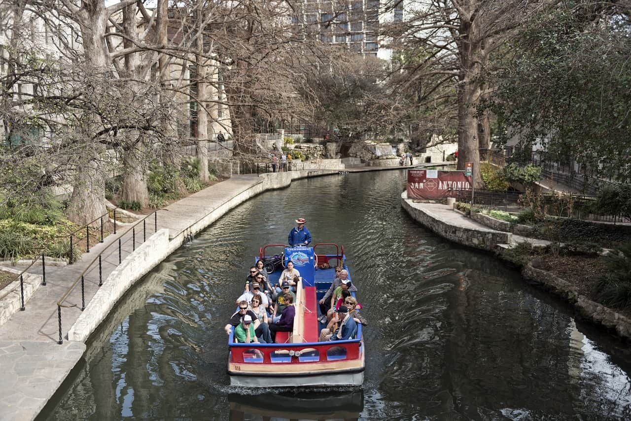 Een bootje met toeristen vaart over een rivier in San Antonio.