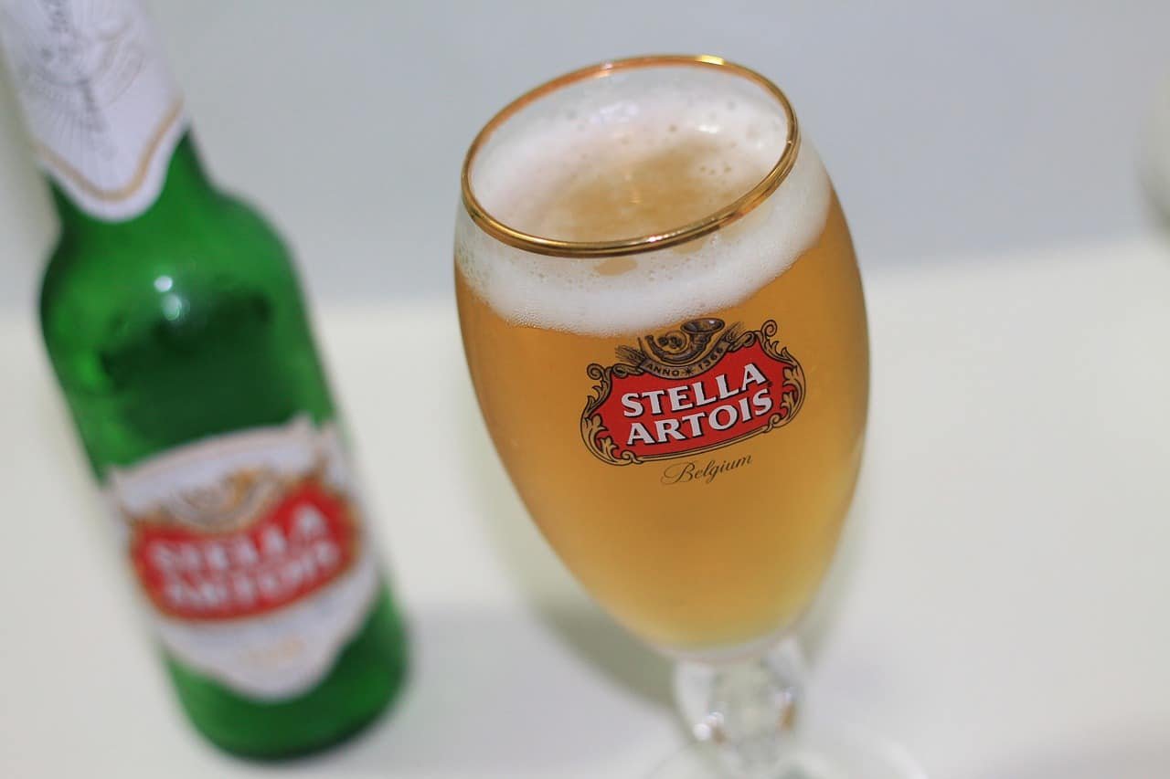 Une bouteille verte et un verre de bière avec Stella Artois