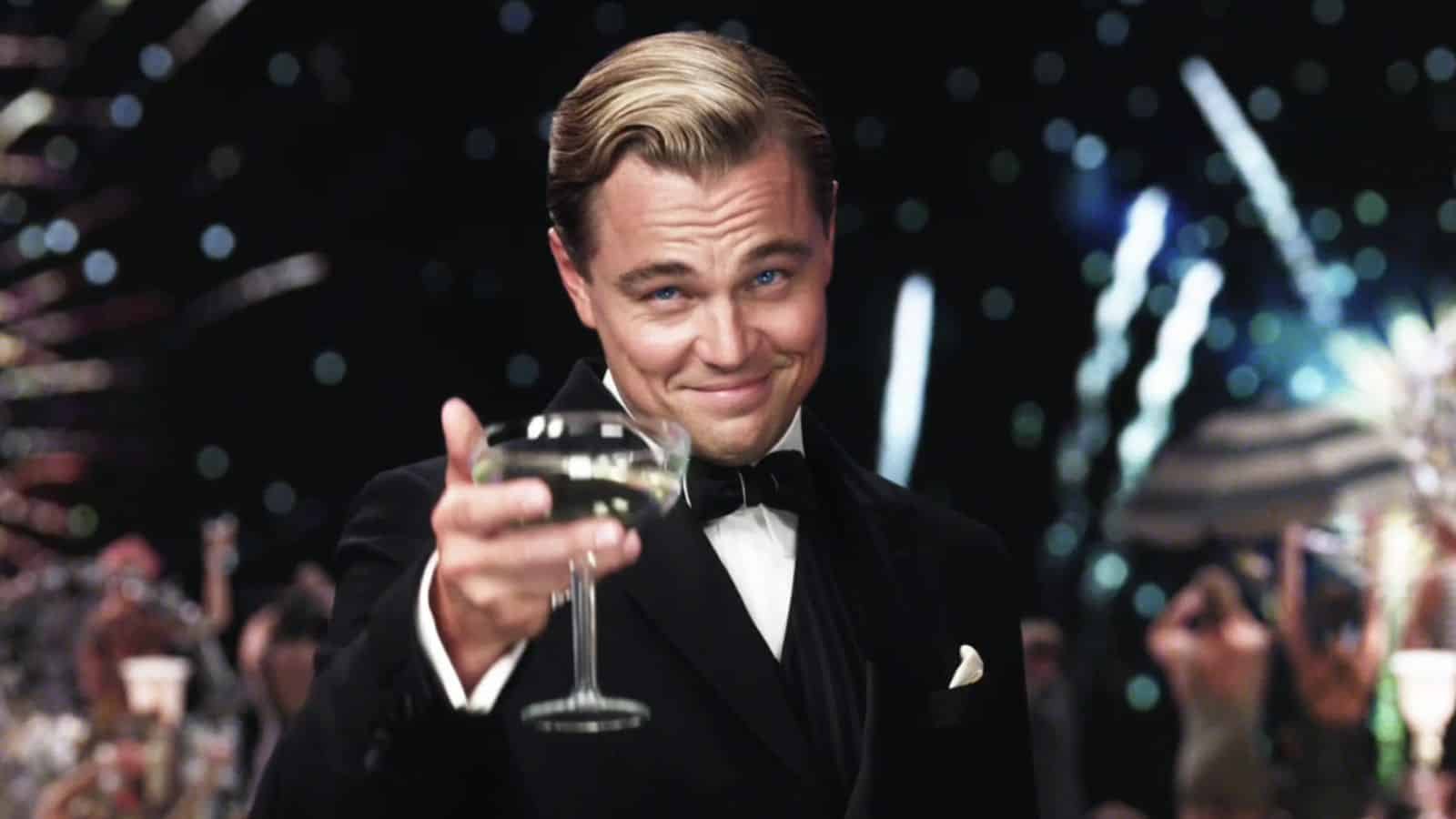 Leonardo DiCaprio heft het glas in The Wolf of Wall Street. Mooie mensen verdienen meer.