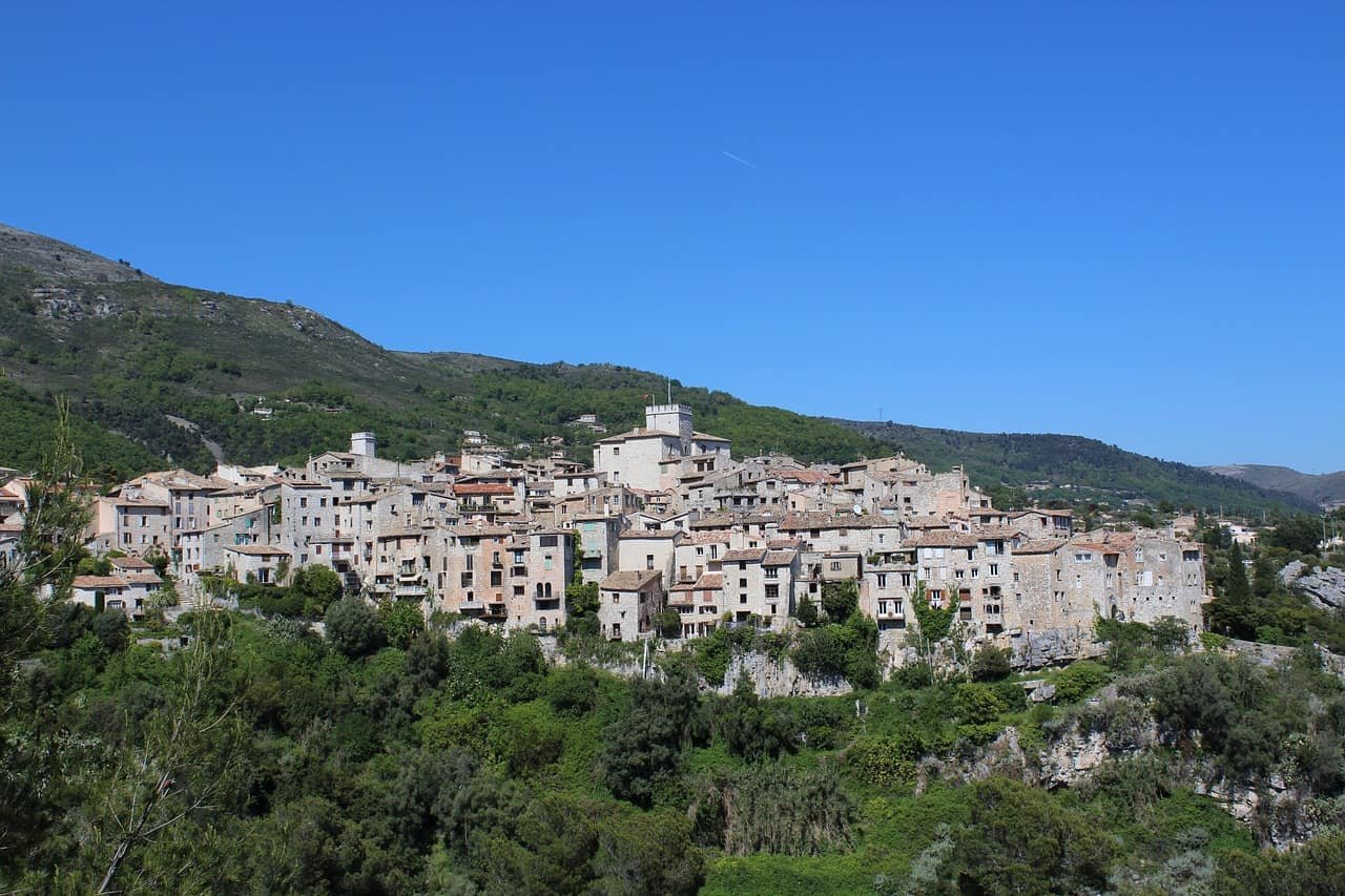 Een beeld van het dorp Tourrettes Sur Loup onder een blauwe hemel.