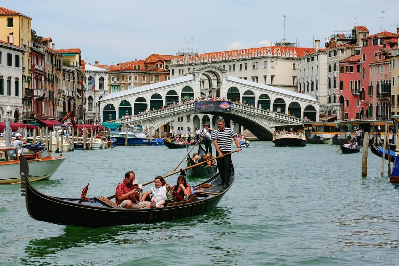 Een gondel vaart met toeristen over een kanaal in Venetië.