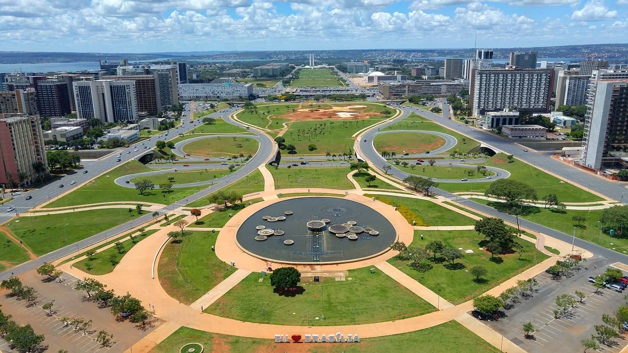 Een beeld van een park met op de achtergrond de skyline van Brasilia.