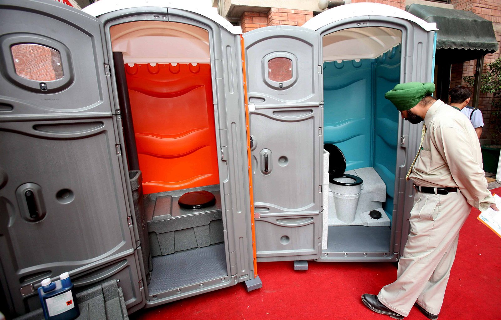 Een Indiër kijkt binnen in een toiletbox op een beurs.