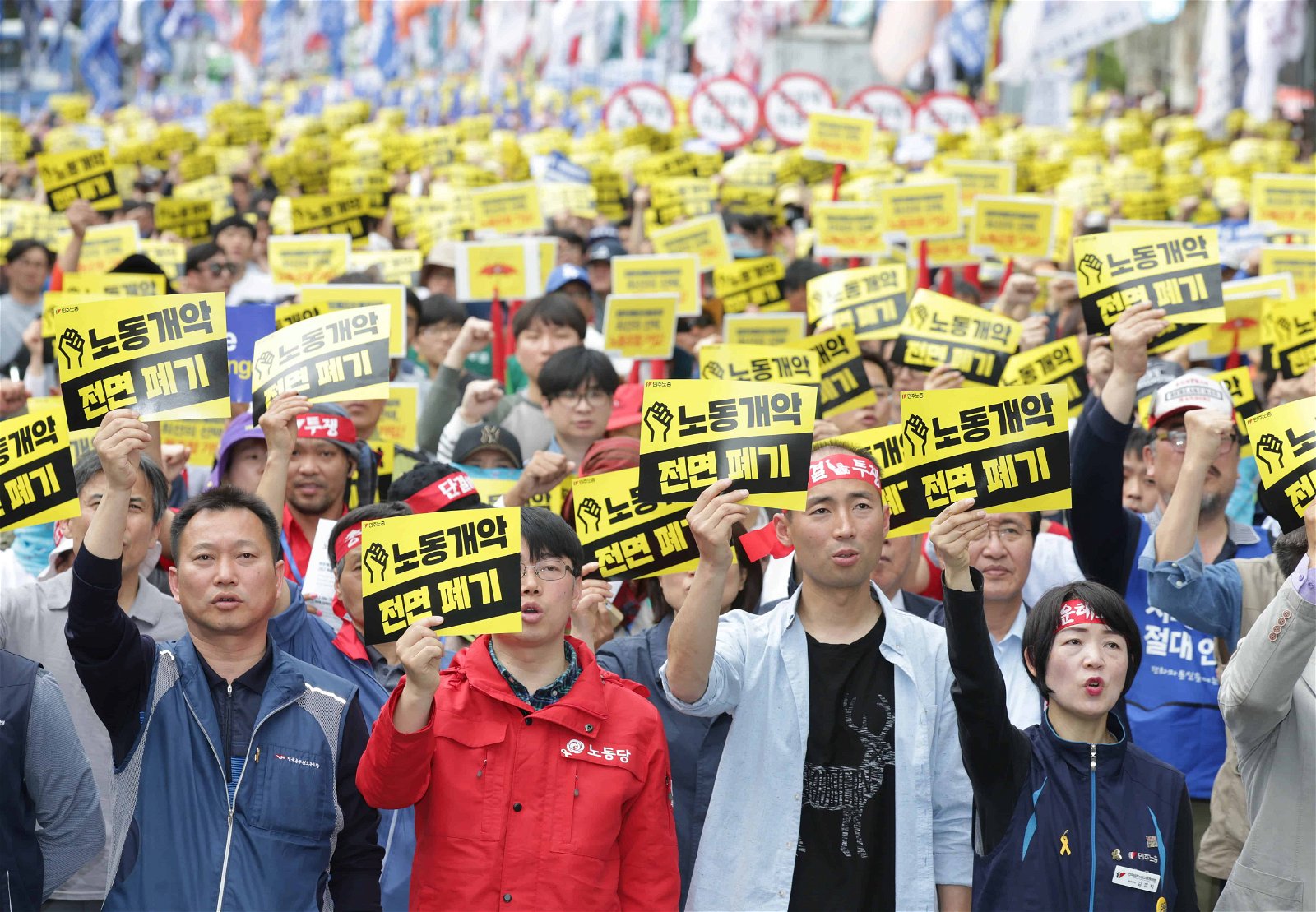 Mensen houden een geel-zwarte boodschap vast tijdens een betoging.