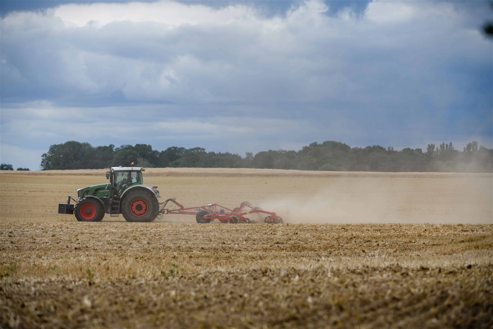 Een tractor rijdt over een veld. Ook de landbouw wordt zwaar getroffen door waterschaarste.