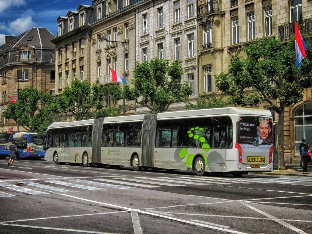 Un bus passe devant un bâtiment portant le drapeau luxembourgeois.