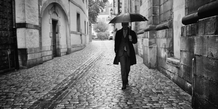 luxembourg man rain umbrella street walk