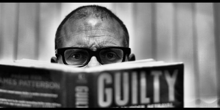man reading book guilty