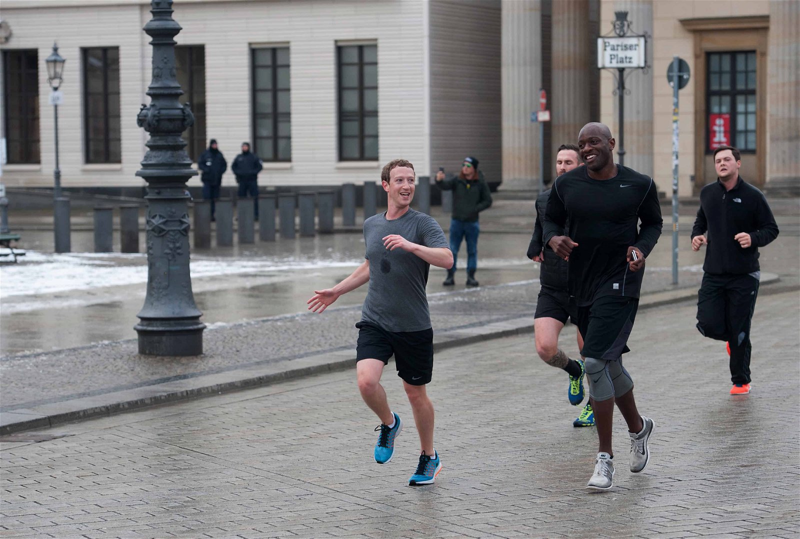 Mark Zuckerberg jogt over straat, omringd door bodyguards.