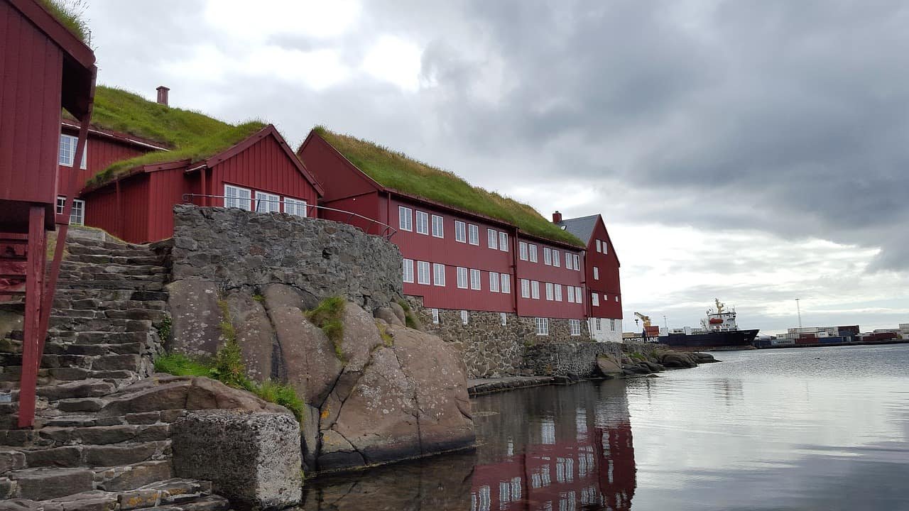 Rode huizen en met gras bedekte daken langs de oever in Torshavn op de Faeröer.