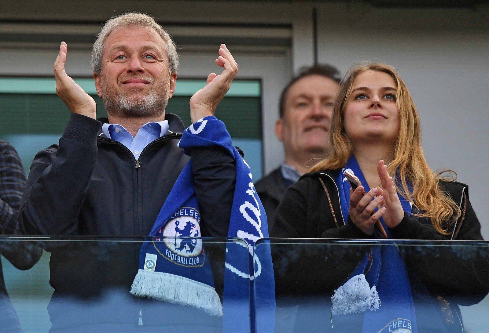 Roman Abramovich applaudiseert met sjaal rond de pols gebonden naast zijn vrouw in de tribune van Chelsea